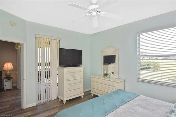 Bedroom featuring access to outside, multiple windows, dark wood-type flooring, and a ceiling fan