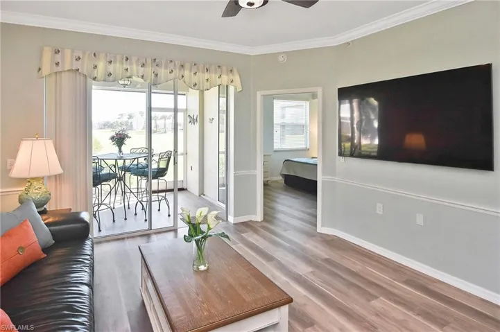 Living area featuring ornamental molding, wood finished floors, and ceiling fan