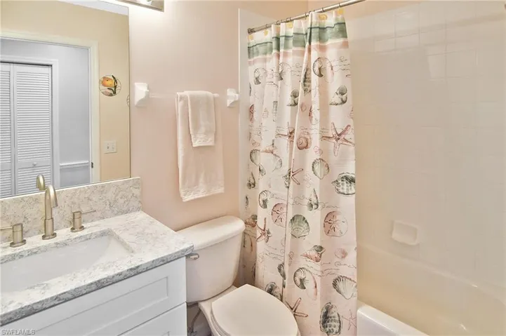 Bathroom featuring vanity, shower / tub combo, and a closet