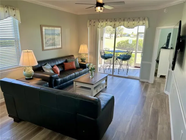 Living area featuring wood finished floors, crown molding, and ceiling fan