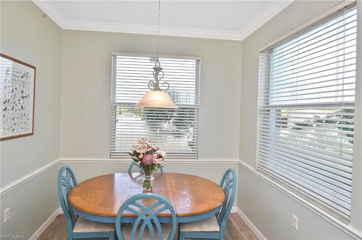 Dining space with ornamental molding and wood finished floors