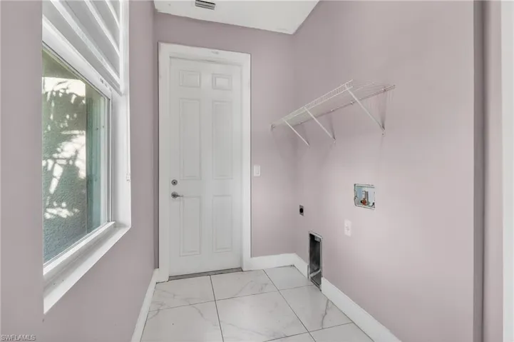 Laundry room featuring hookup for an electric dryer, hookup for a washing machine, and light marble finish flooring