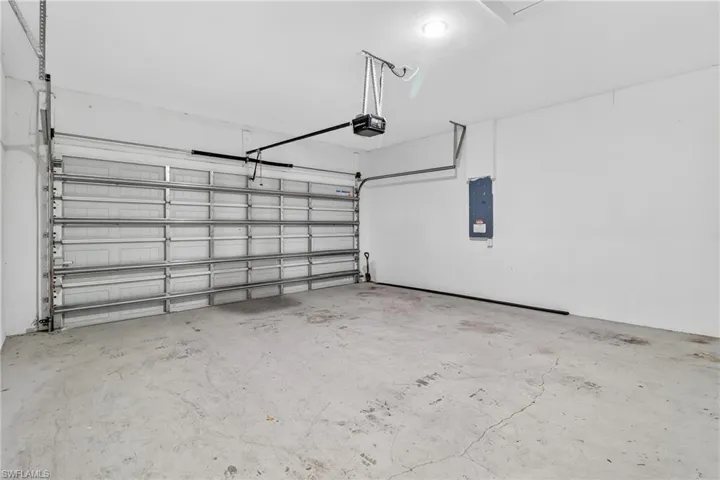 Garage featuring electric panel and a garage door opener