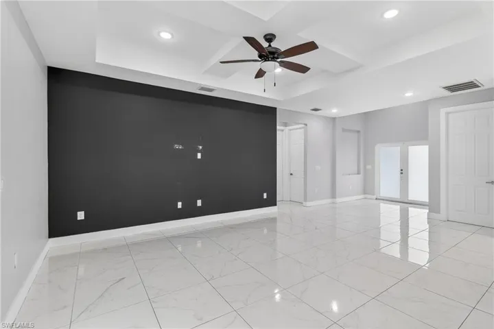 Unfurnished room featuring ceiling fan, recessed lighting, coffered ceiling, and french doors