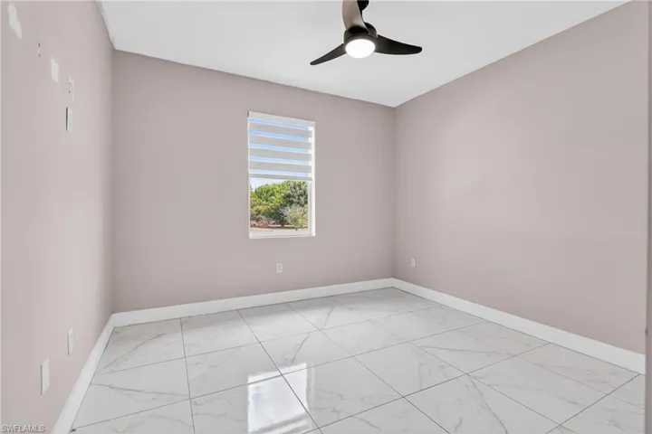 Empty room with light marble finish flooring and ceiling fan