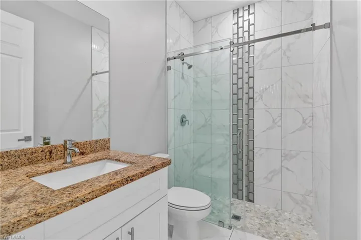 Full bath featuring a shower stall and vanity