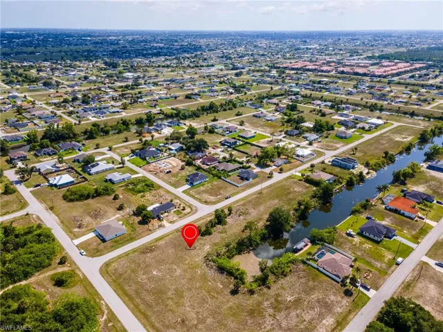 Aerial view of property's location featuring a large body of water and nearby suburban area