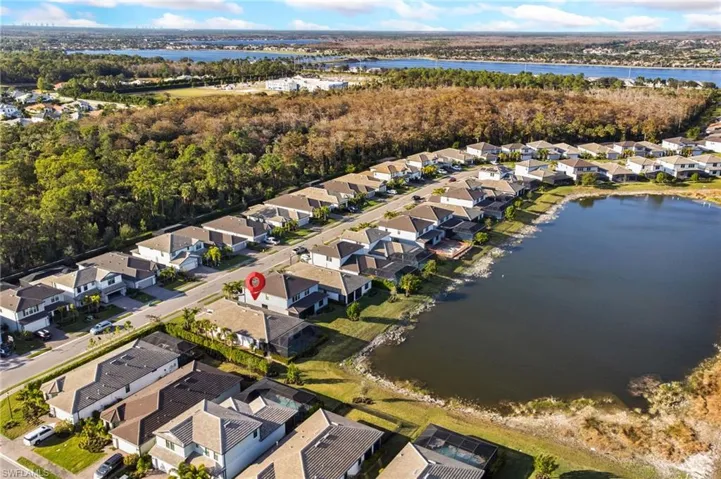 Aerial view of property and surrounding area with nearby suburban area and a nearby body of water
