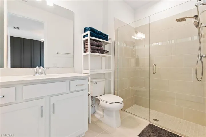 Bathroom with vanity, a shower stall, and light tile patterned floors