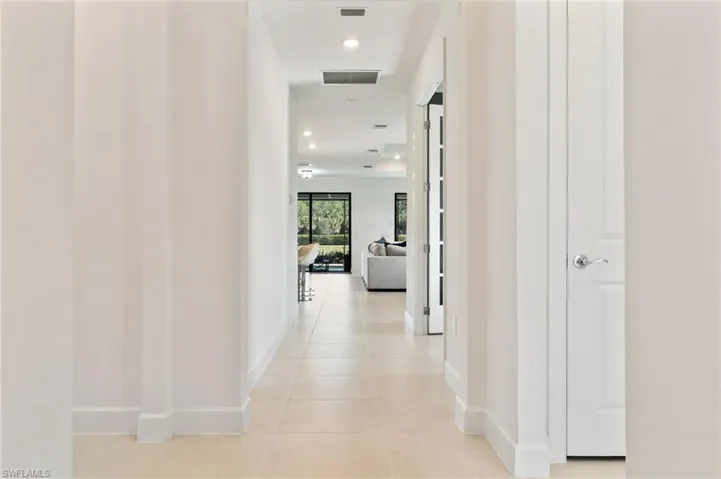 Hall with recessed lighting and light tile patterned floors