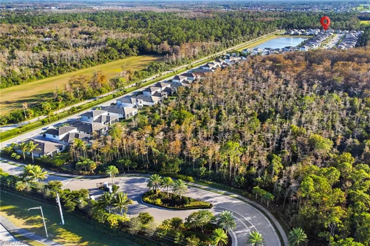 Aerial view of property's location with a forest and a nearby body of water