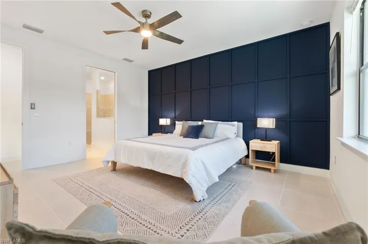 Bedroom with a decorative wall, a ceiling fan, and an accent wall