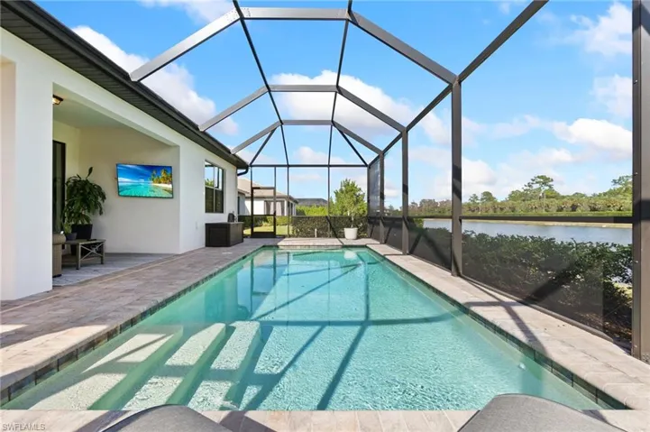 Outdoor pool with a lanai, a sunroom, and a patio