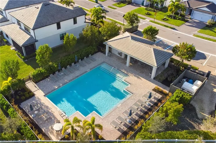 Community pool with a patio area and a residential view