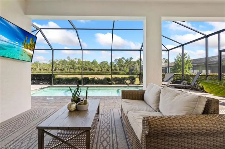 Swimming pool featuring a sunroom, a patio area, a lanai, and an outdoor living space