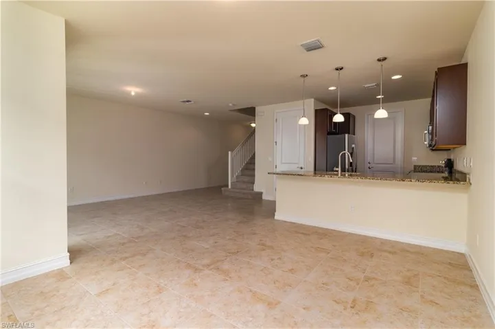 Unfurnished living room with sink and light tile floors