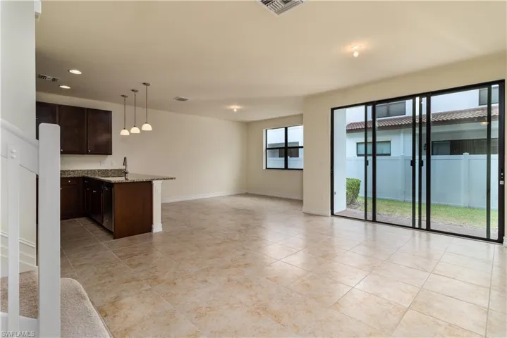 Kitchen featuring light stone counters, plenty of natural light, and light tile floors