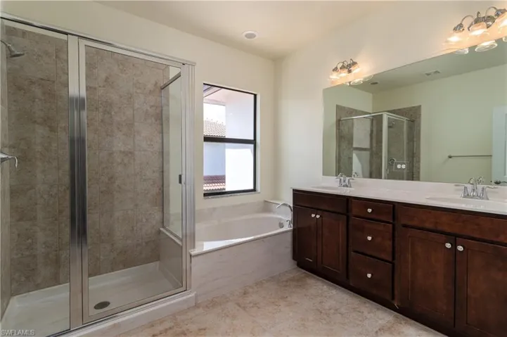 Bathroom with dual vanity, independent shower and bath, and tile flooring
