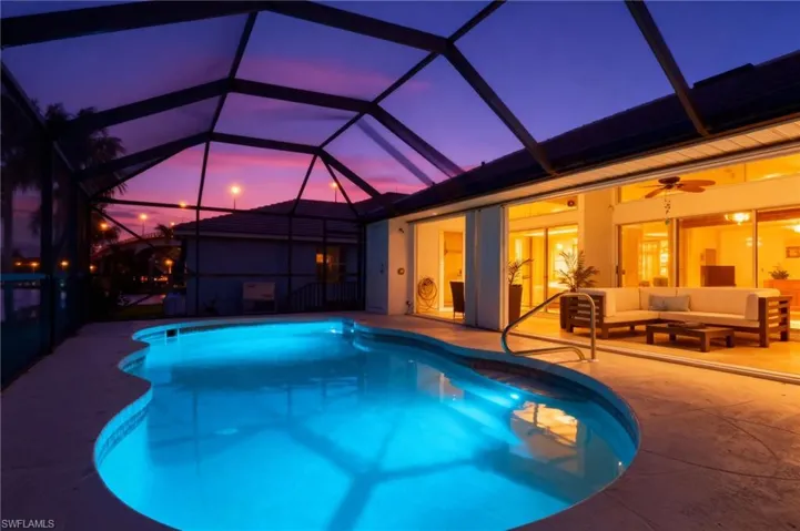 Swimming pool featuring glass enclosure, a sunroom, ceiling fan, outdoor lounge area, and a patio