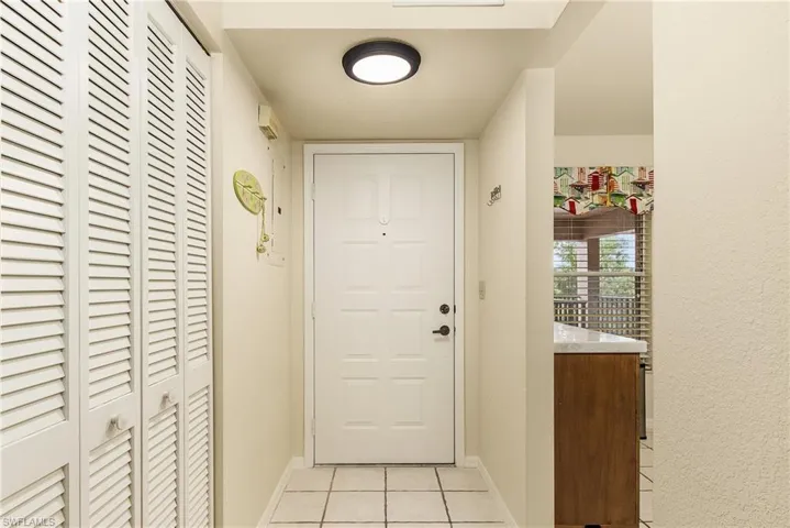 Doorway with tile patterned floors and electric panel