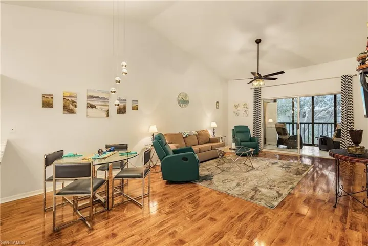 Living room featuring wood finished floors, high vaulted ceiling, and a ceiling fan