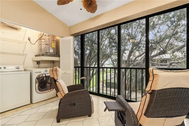 Washroom with washer and clothes dryer, tile patterned floors, ceiling fan, and water heater