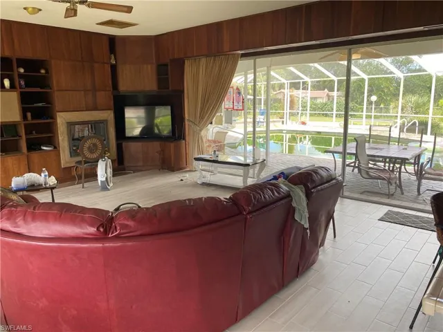 Living room featuring wood walls and ceiling fan