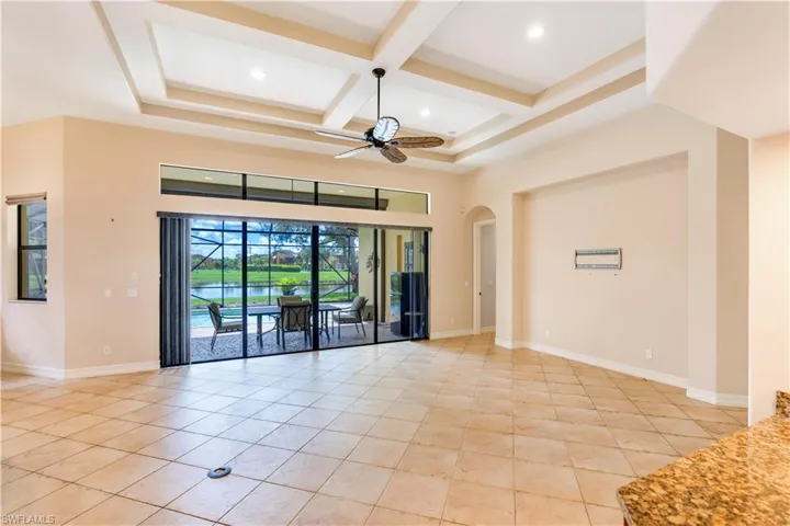 Unfurnished room with coffered ceiling, ceiling fan, beamed ceiling, and light tile floors