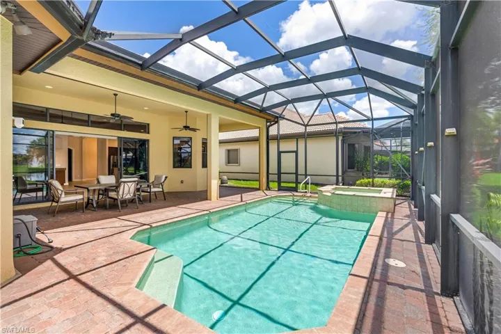 View of swimming pool featuring ceiling fan, glass enclosure, an in ground hot tub, and a patio