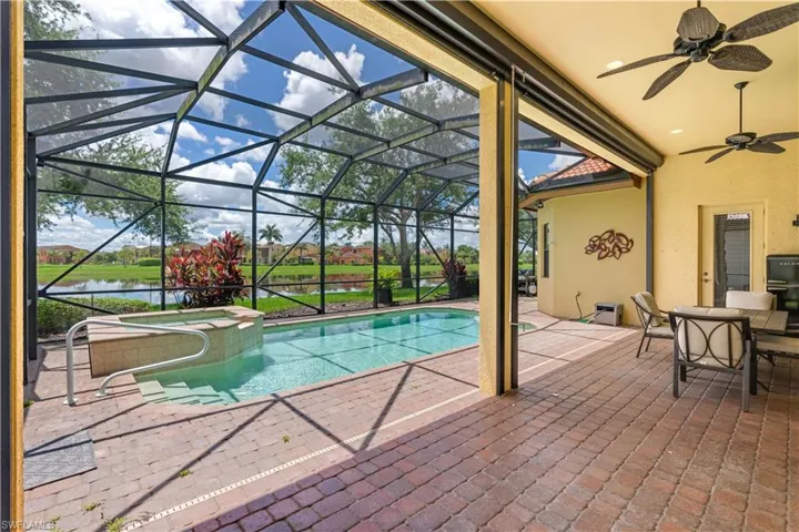 View of swimming pool with a patio, a lanai, an in ground hot tub, and ceiling fan
