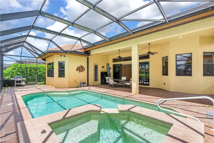 View of pool featuring a patio, a lanai, an in ground hot tub, and ceiling fan