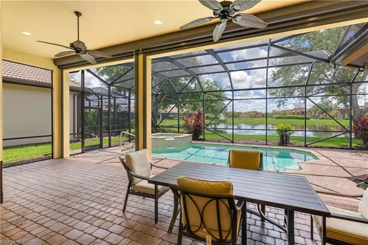Sunroom / solarium featuring ceiling fan and a water view