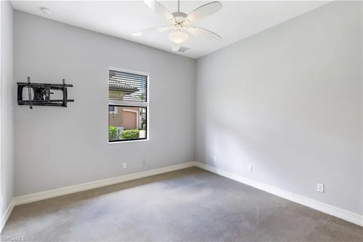 Carpeted spare room featuring ceiling fan