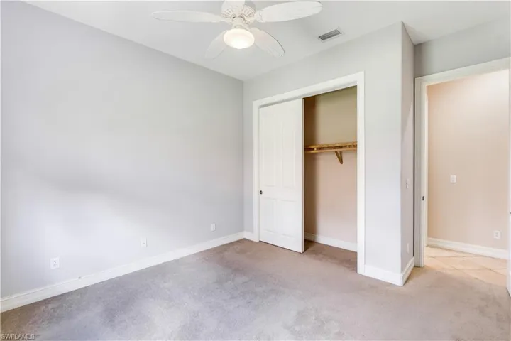 Unfurnished bedroom with a closet, ceiling fan, and carpet floors