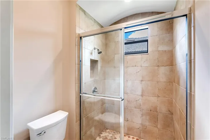 Bathroom featuring walk in shower and toilet