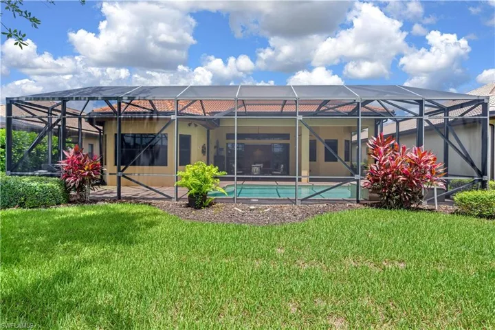 Back of house featuring a lanai and a yard