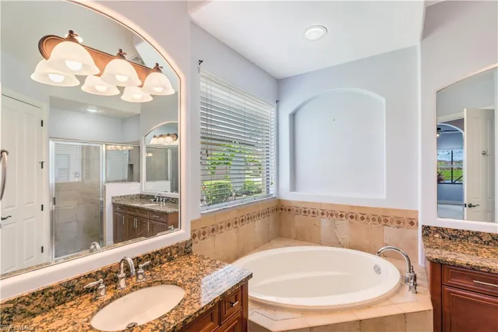 Bathroom with double vanity, plenty of natural light, and plus walk in shower