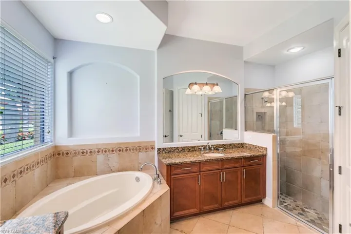 Bathroom with tile floors, plus walk in shower, and vanity with extensive cabinet space