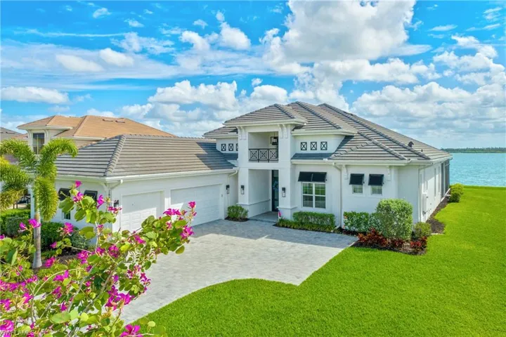 View of front of home with a garage, a front yard, decorative driveway, stucco siding, and a tile roof