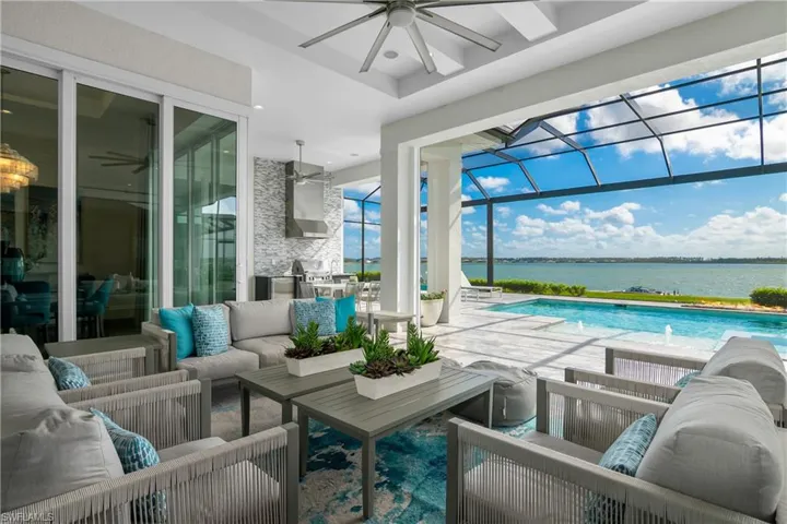 Swimming pool with an outdoor living space, a lanai, a patio area, and a water view