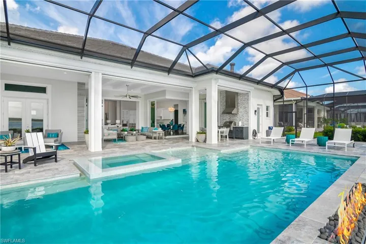 View of pool featuring a patio area, a lanai, a sunroom, an outdoor living space, and a pool with connected hot tub