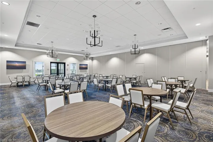 Dining area with a tray ceiling, dark carpet, and recessed lighting