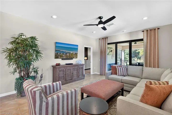 Living room featuring ceiling fan, light tile patterned flooring, and recessed lighting