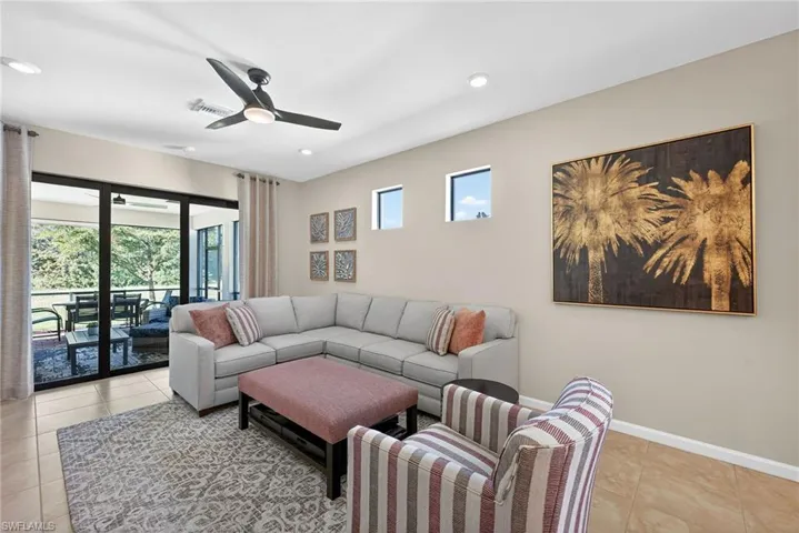 Living area featuring light tile patterned flooring, healthy amount of natural light, ceiling fan, and recessed lighting