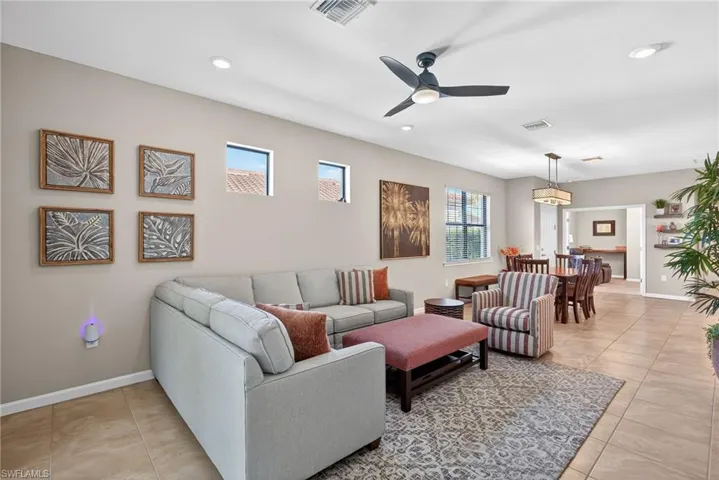 Living room featuring light tile patterned floors, ceiling fan, and recessed lighting
