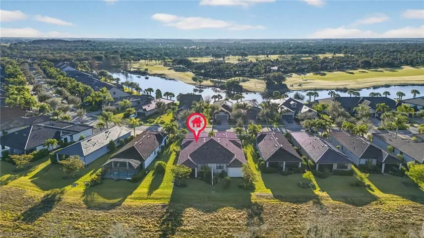 Aerial view of residential area featuring a nearby body of water and a local golf course