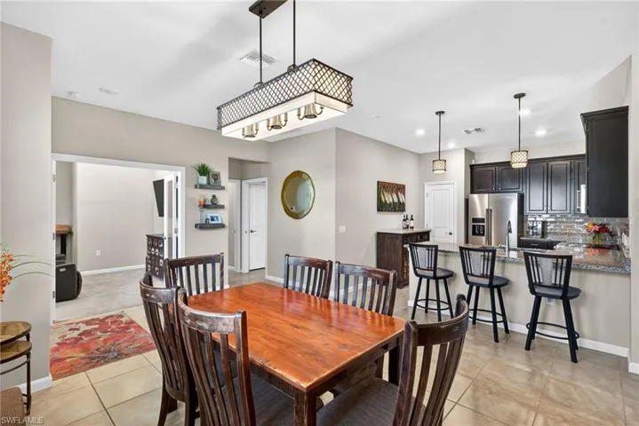 Dining space with light tile patterned floors and recessed lighting