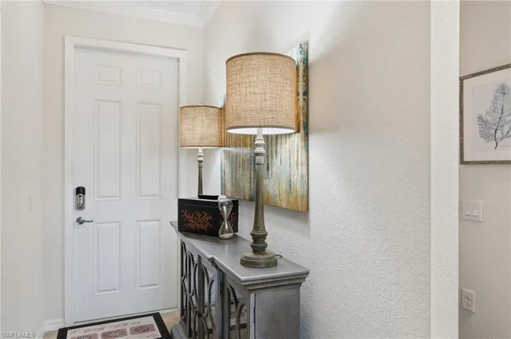Entryway featuring a textured wall and crown molding