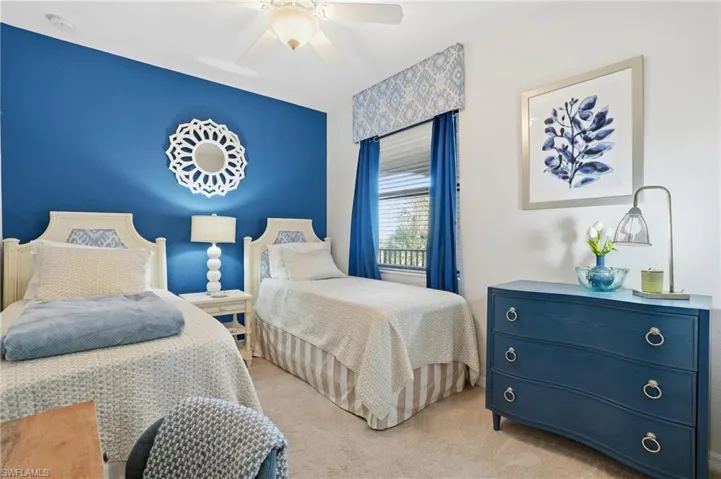 Carpeted bedroom featuring a ceiling fan