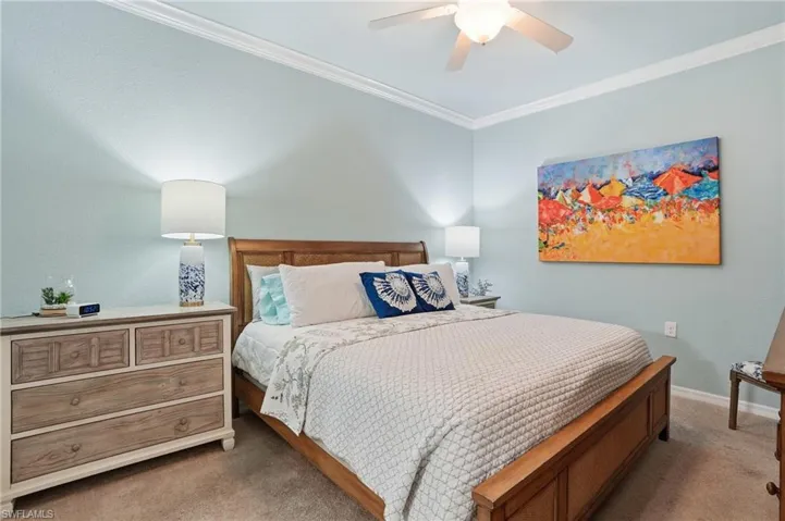 Bedroom with carpet, ornamental molding, and ceiling fan